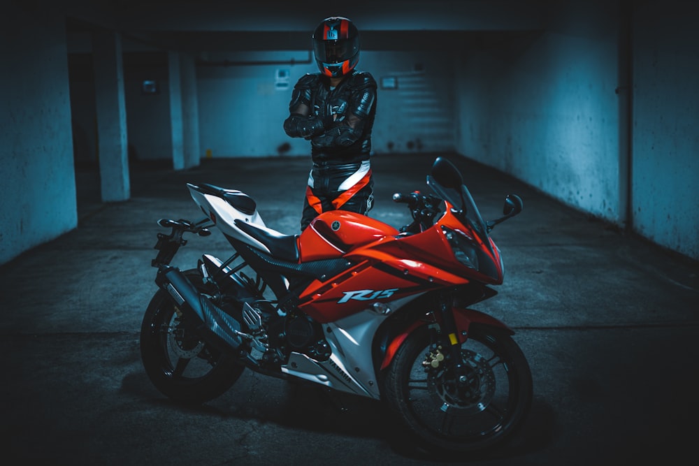 person standing in front of black and red sports bike