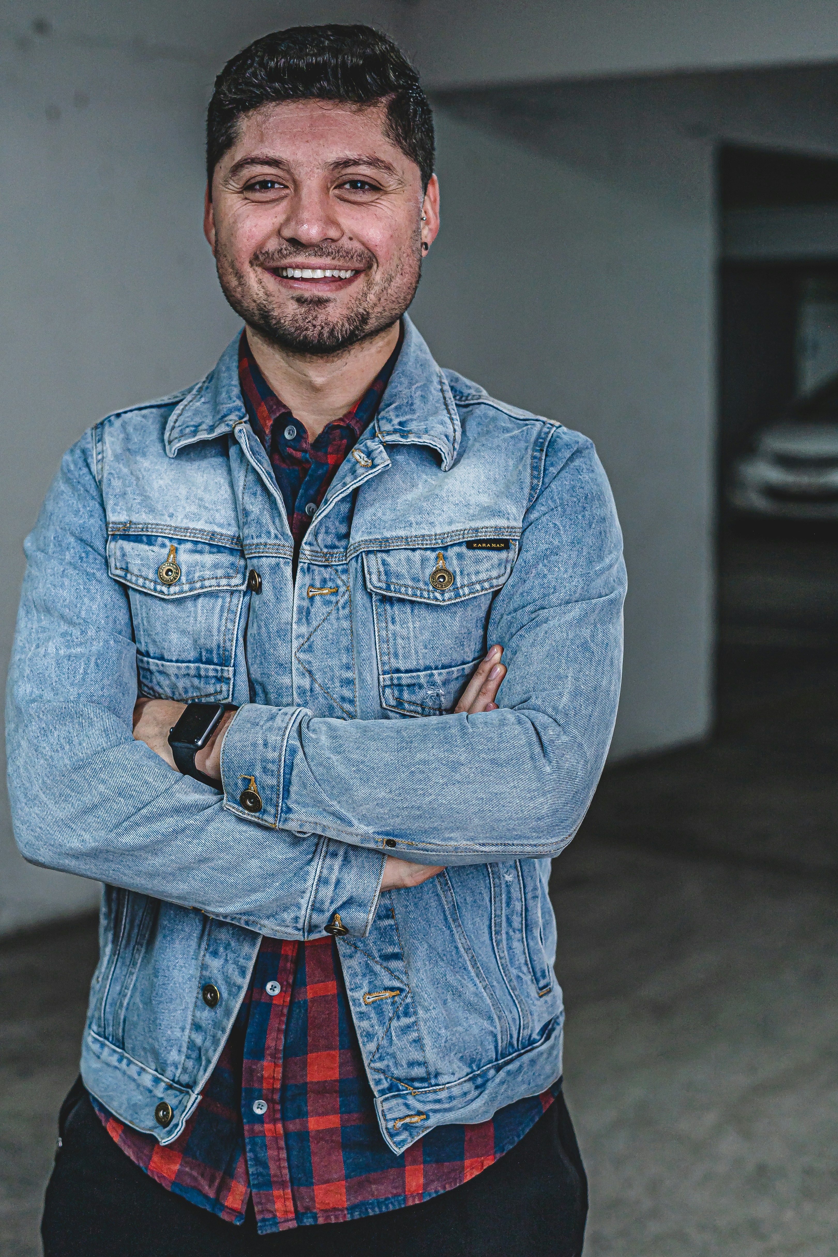 man wearing blue denim jacket smiling