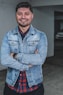 man wearing blue denim jacket smiling