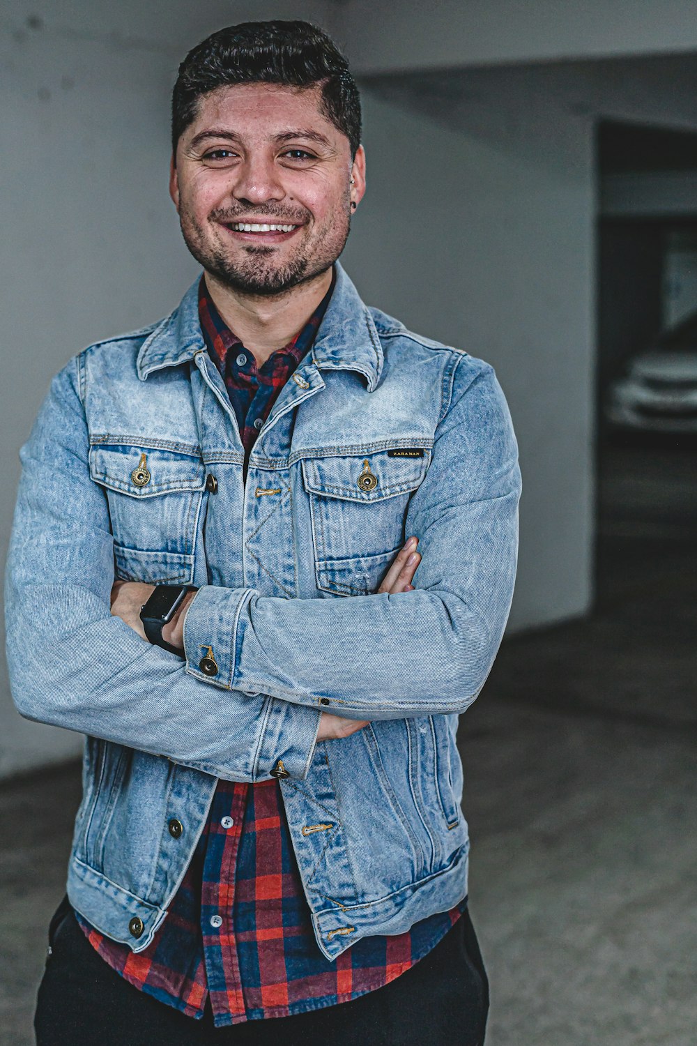 man wearing blue denim jacket smiling