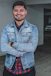 man wearing blue denim jacket smiling