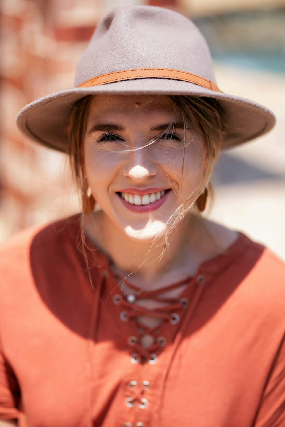 woman in gray and orange hat and orange top