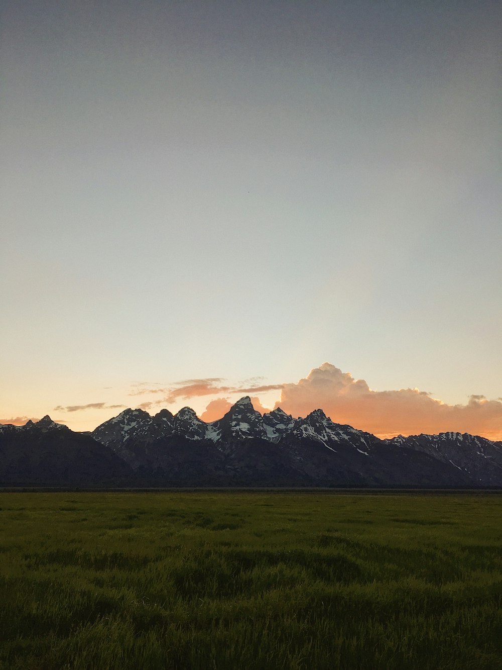 snow-covered mountain near green field