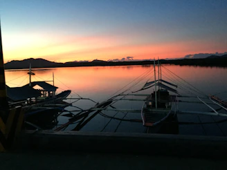 A serene sunset over Verde Island’s turquoise waters with traditional boats gently floating.
