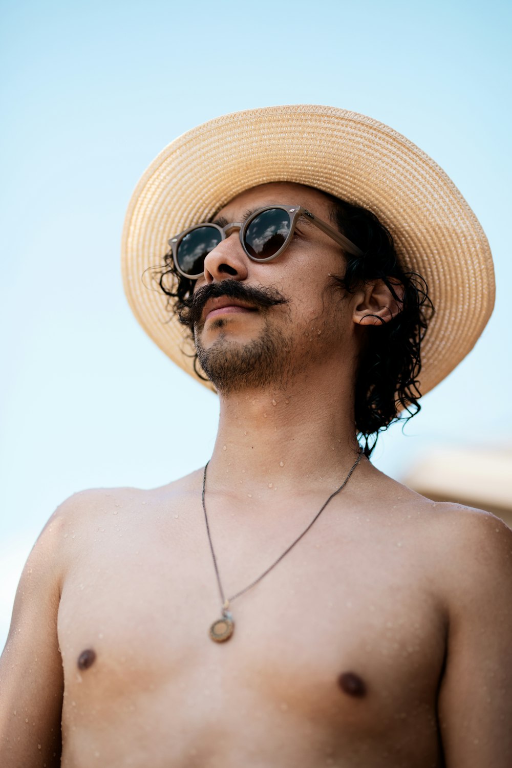 topless man wearing brown sun hat