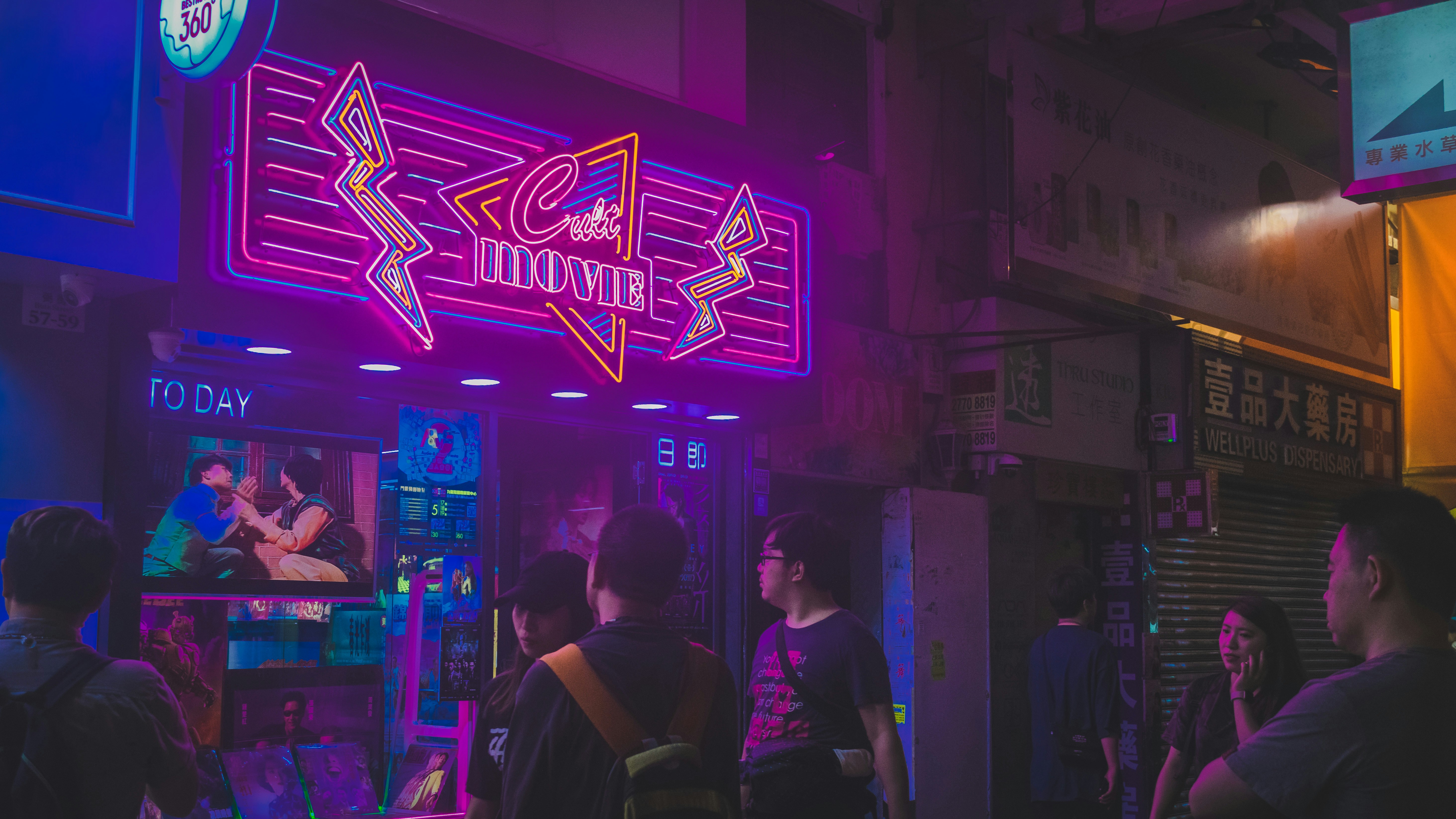 people standing outside movie building