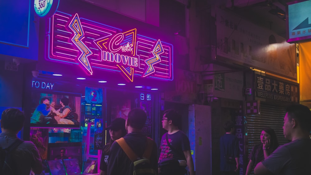 people standing outside movie building