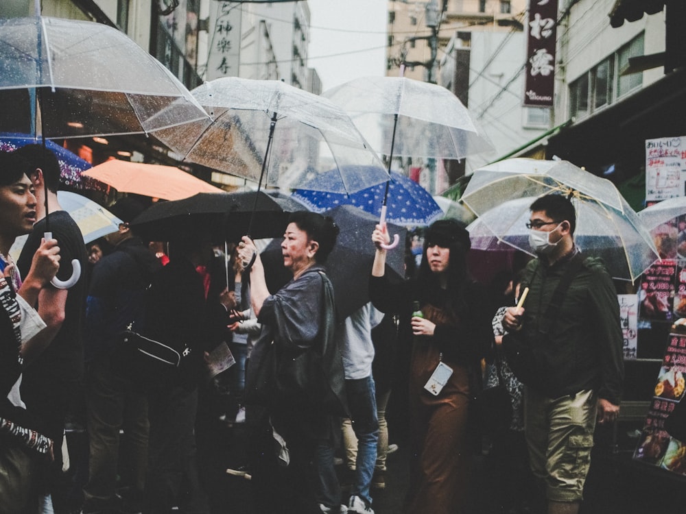pessoas segurando guarda-chuvas