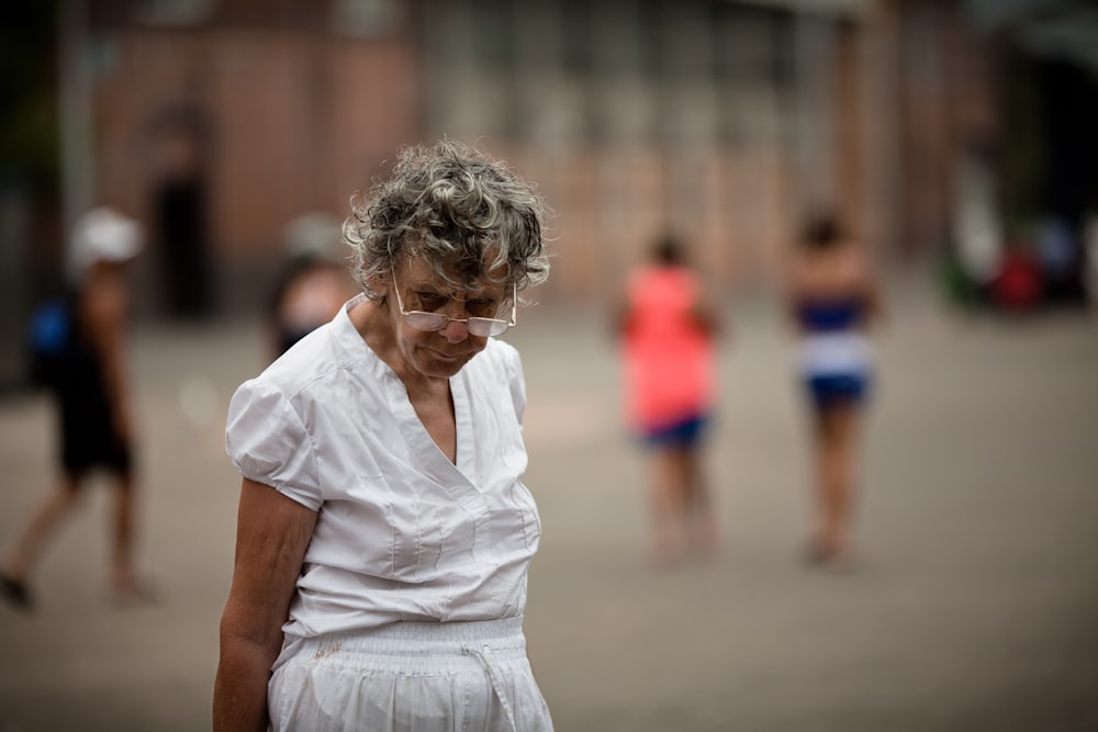 selective focus photography of standing woman wearing eyeglasses