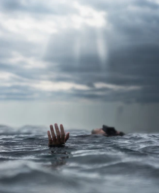 person in water drowning because of life anxieties during daytime