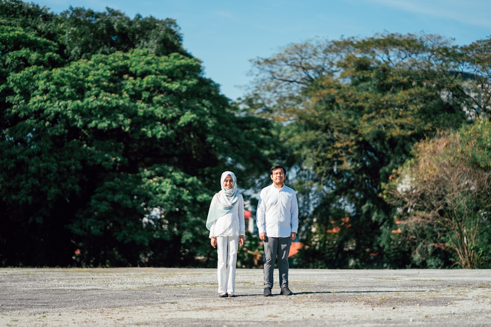 woman wearing white hijab standing beside man wearing dress shirt