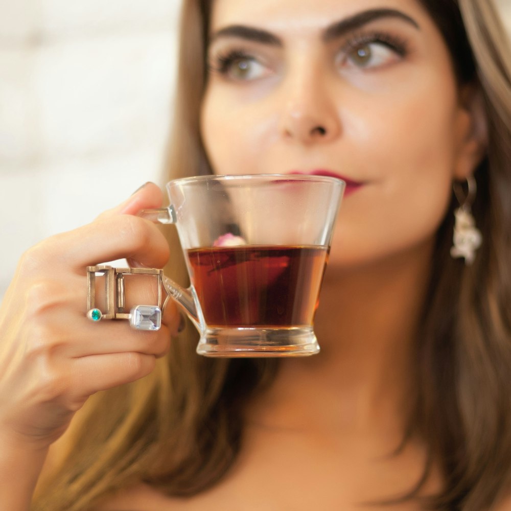 woman holding clear glass cup