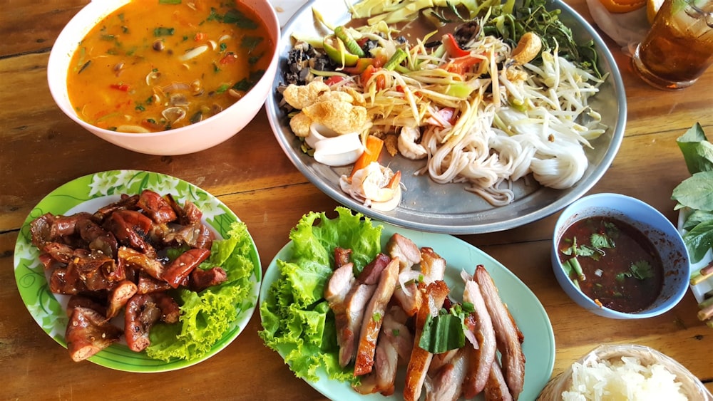 pasta with vegetables near meat with cabbage and stewed food in bowl