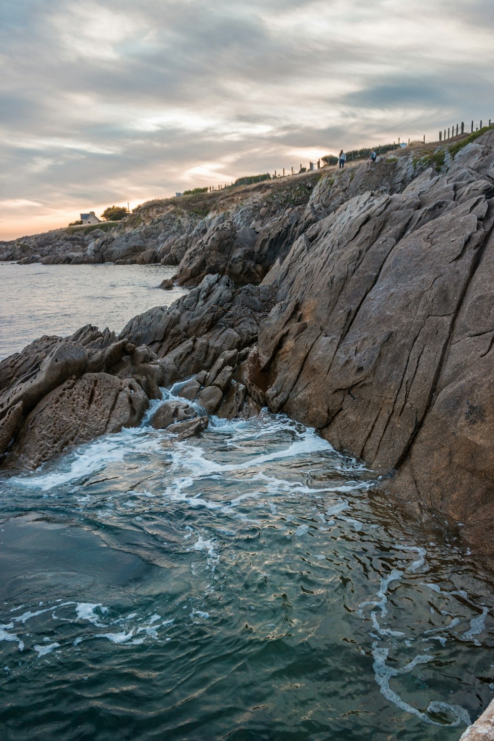 gros rochers au bord d’un plan d’eau pendant la journée