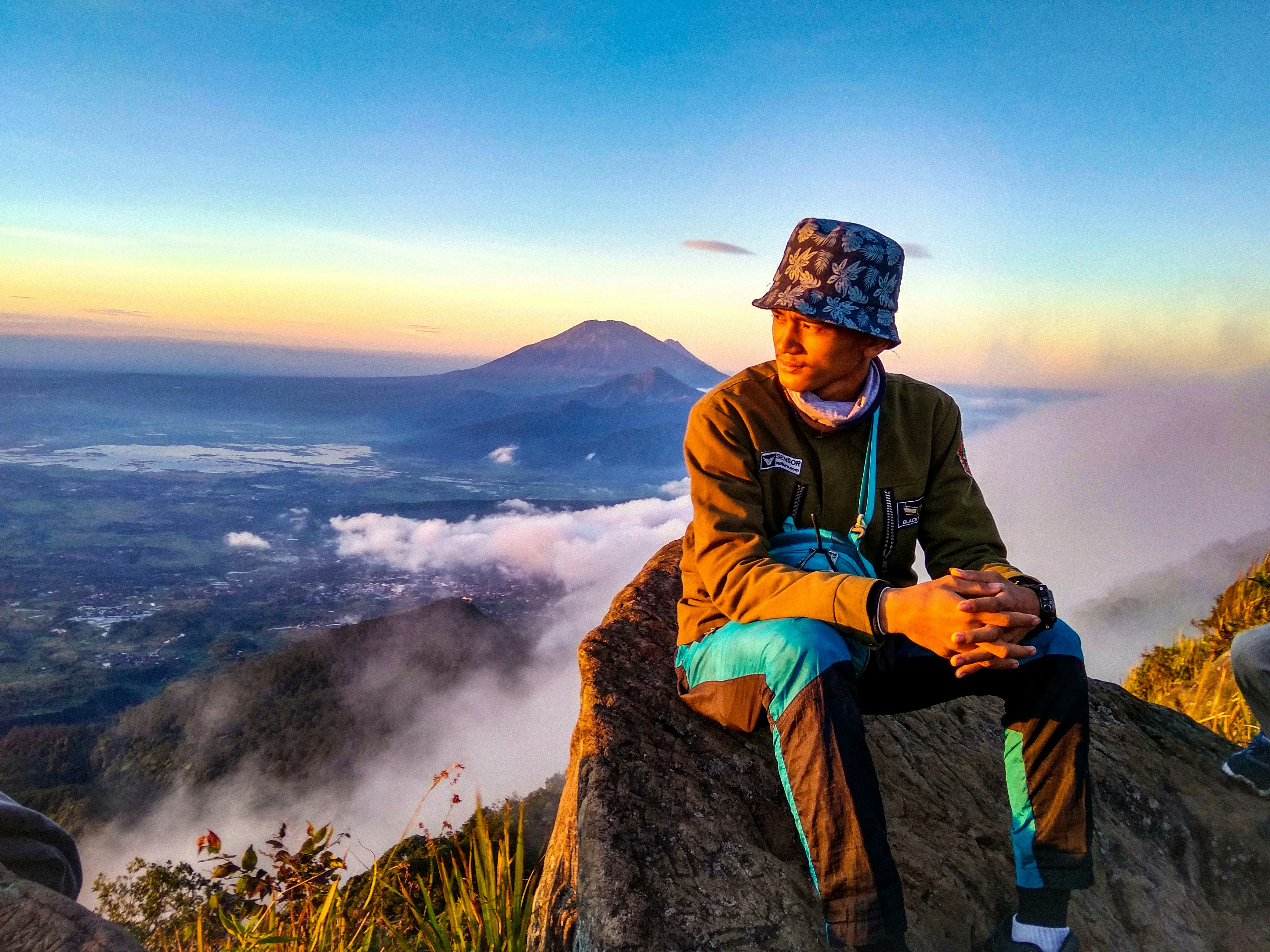 Pria duduk di atas batu