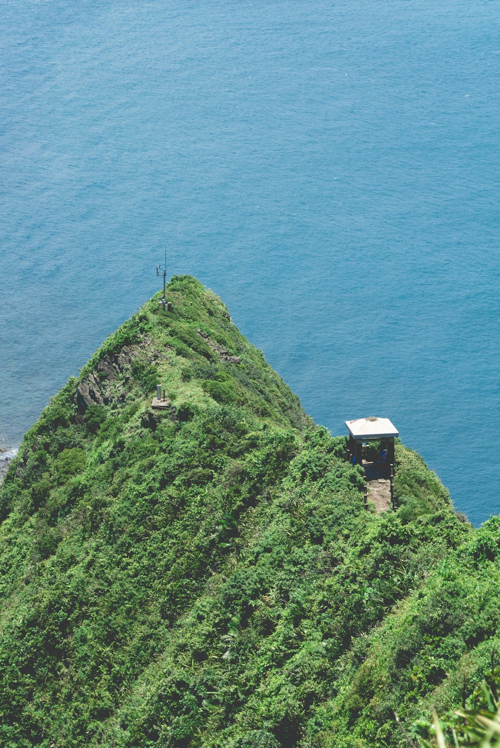 white and brown building on top of hill overlooking sea