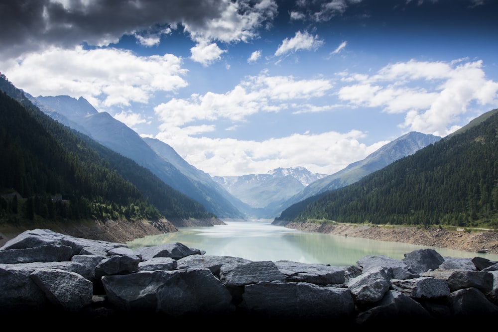 photography of lake between mountain during daytime