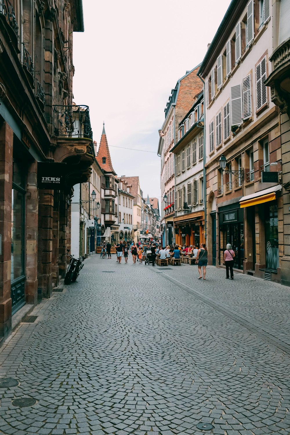 people walking on road between building during daytime