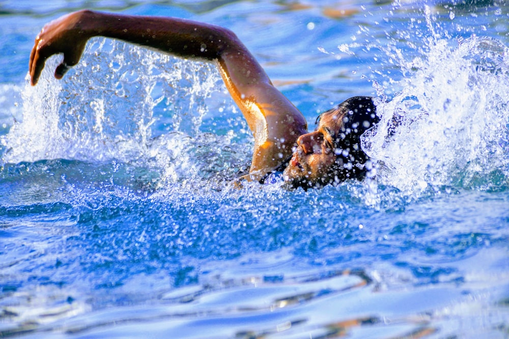 man swimming in body of water