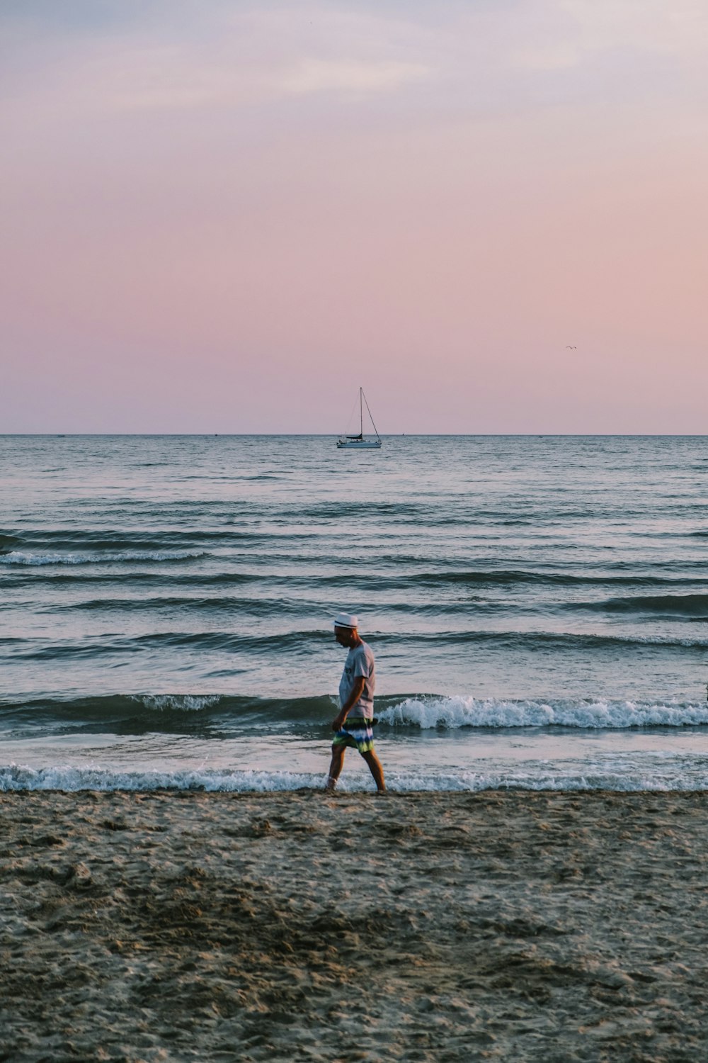 person standing beside body of water during golden hour