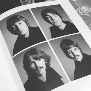 poster of four men on gray surface