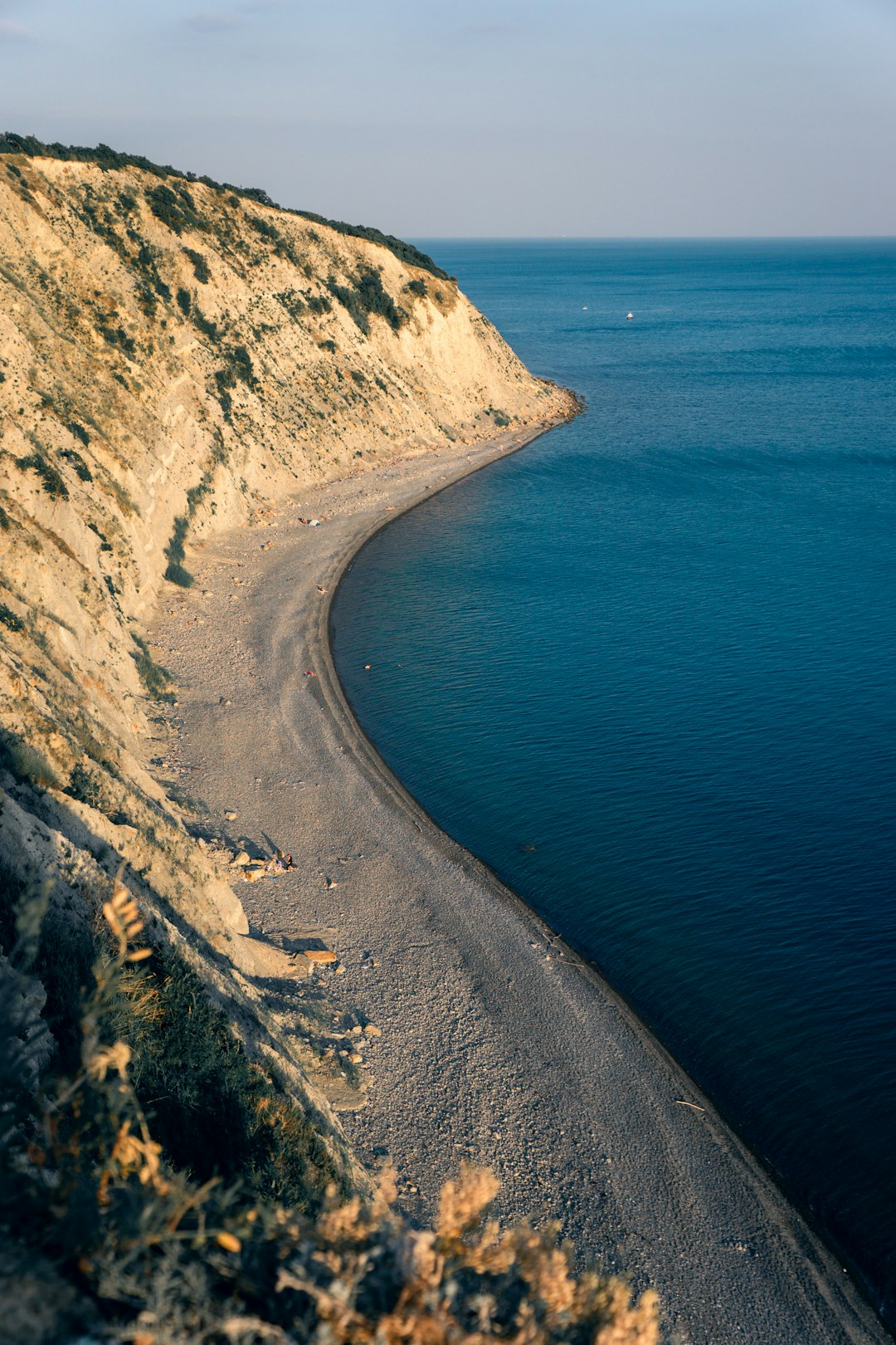 photography of brown mountain cliff beside seashore during daytime
