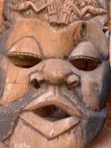 Close-up of an intricately carved wooden tribal mask from Africa.