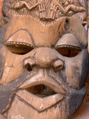 Close-up of a vibrant wooden African mask with intricate carvings and rich colors.