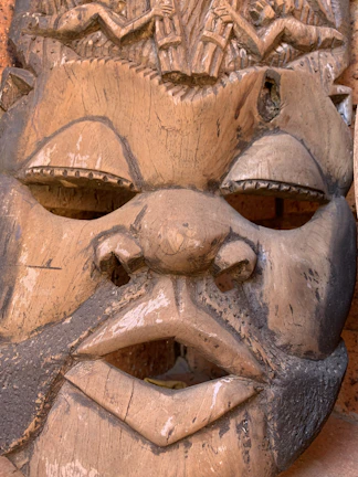 Close-up of handcrafted Myènè wooden masks used in cultural ceremonies.