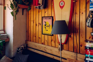 Interior of a bungalow showing a comfy bed and surfboard decoration