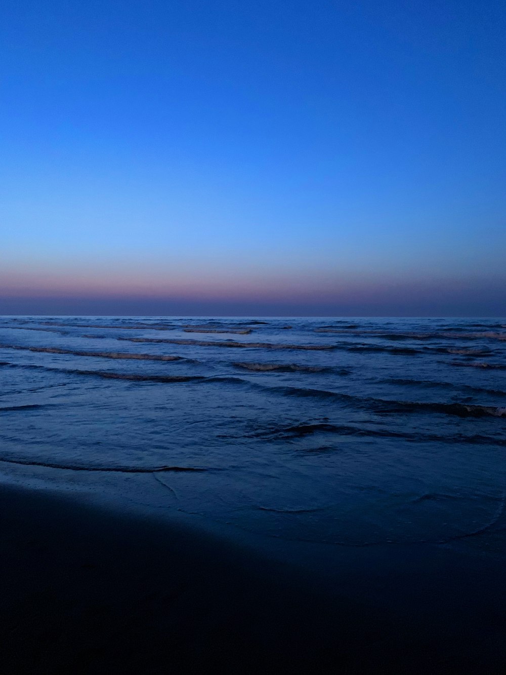 Una persona caminando por la playa al atardecer