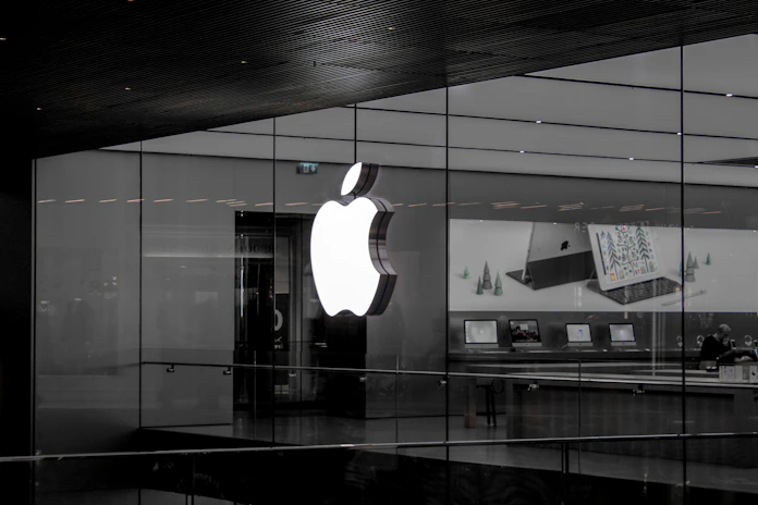 Cozy store interior showcasing a sleek display of Apple products under warm lighting.
