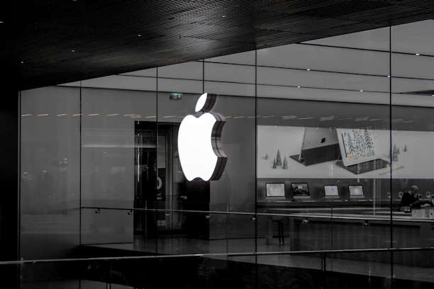 A sleek display of modern Apple products including iPhones, iPads, and MacBooks with soft natural lighting.