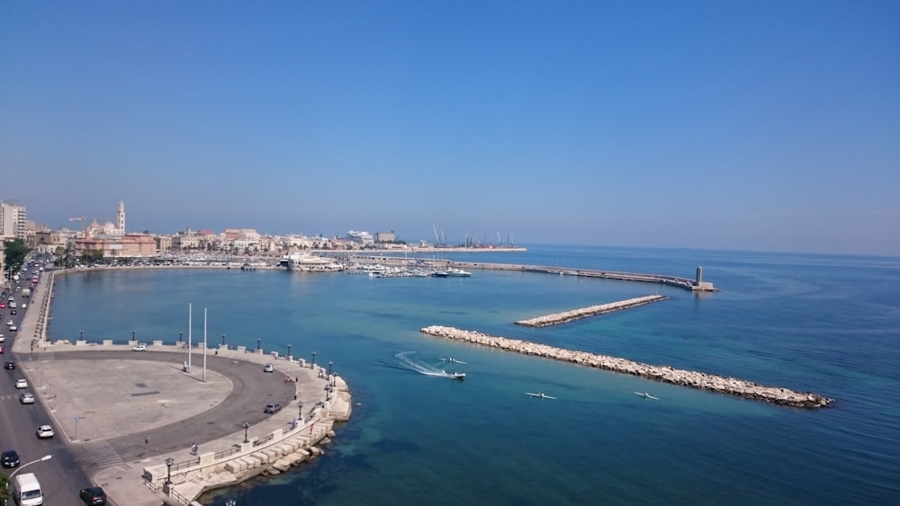 aerial photography of concrete pavement beside body of water during daytime