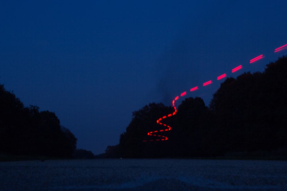 a long exposure photo of a road at night