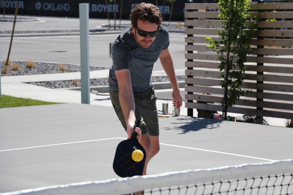 man playing tennis during daytime