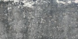 Weathered and textured concrete surface with patches of discoloration, giving a rustic and distressed appearance.