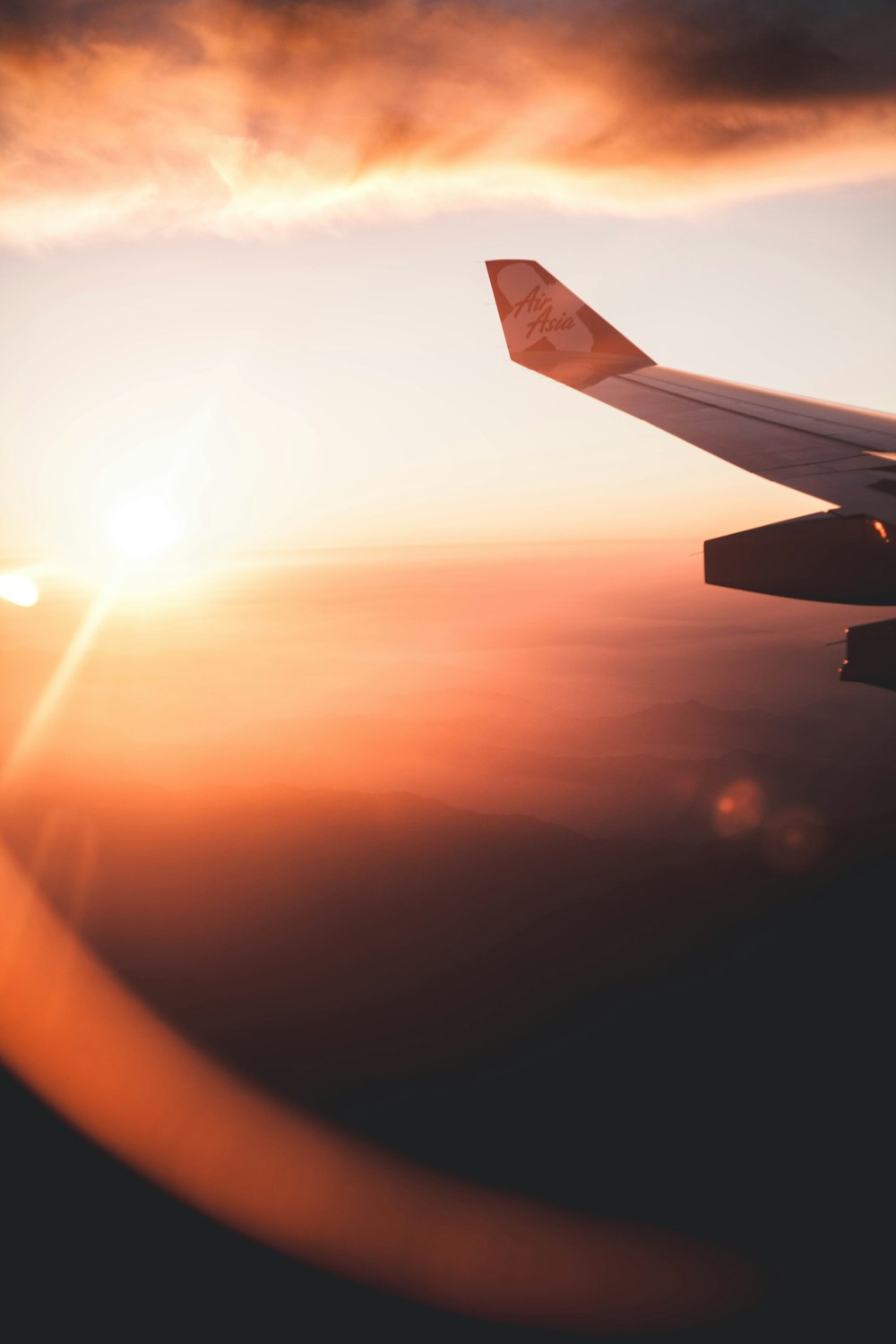 a view of the wing of an airplane as the sun sets