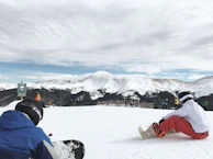 Instructors demonstrating terrain assessment techniques to a group of attentive snowboarders.