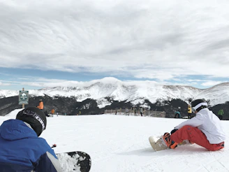 Instructors demonstrating terrain assessment techniques to a group of attentive snowboarders.