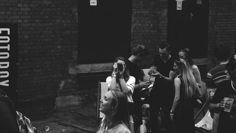 people standing near brick wall