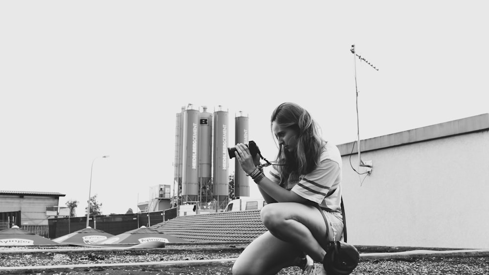 Fotografía en escala de grises de mujer tomando foto
