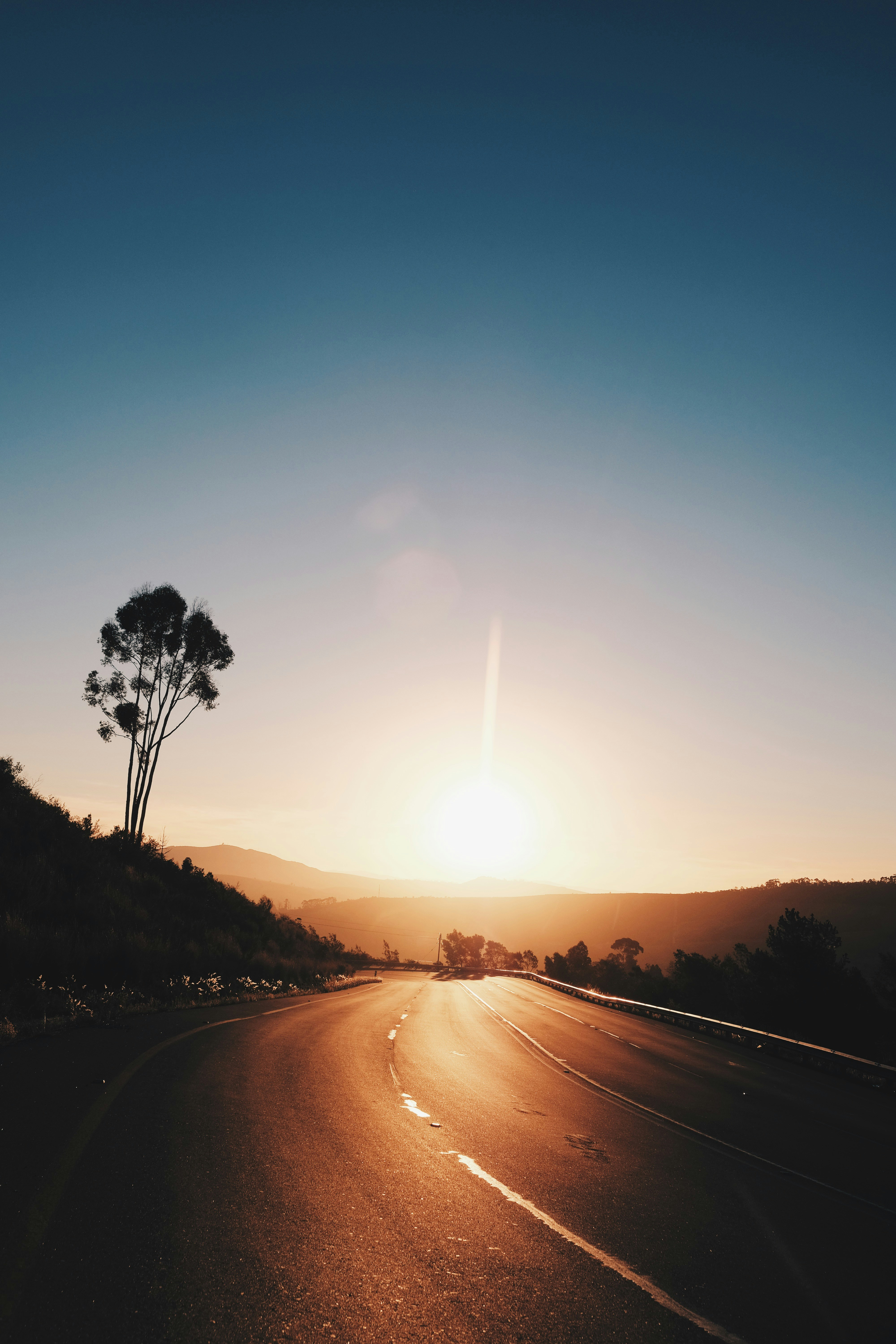 asphalt road leading to the mountain during golden hour