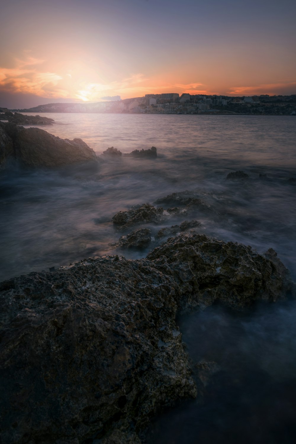 the sun is setting over a body of water