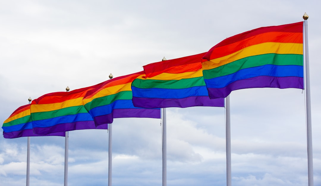 multicolored flags under white sky, This photo of pride flags was taken in Reykjavik, Iceland, on 12. August 2018. The flags were next to the Harpa opera house.<p></figure>My name for this photo is "Proud United Flags" because the six flags stand proud and tall. Together they create one continuous strong rainbow.</p><p>I have seen this photo is being used in the support of LGBTQ+ and diversity topics. Keep up the good work!