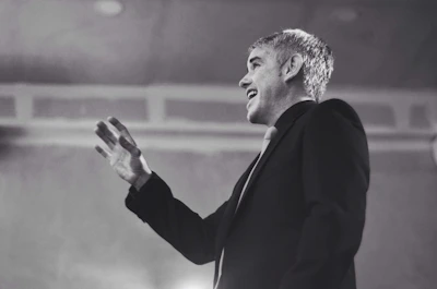 Close-up of a confident speaker using expressive hand gestures during a corporate presentation.