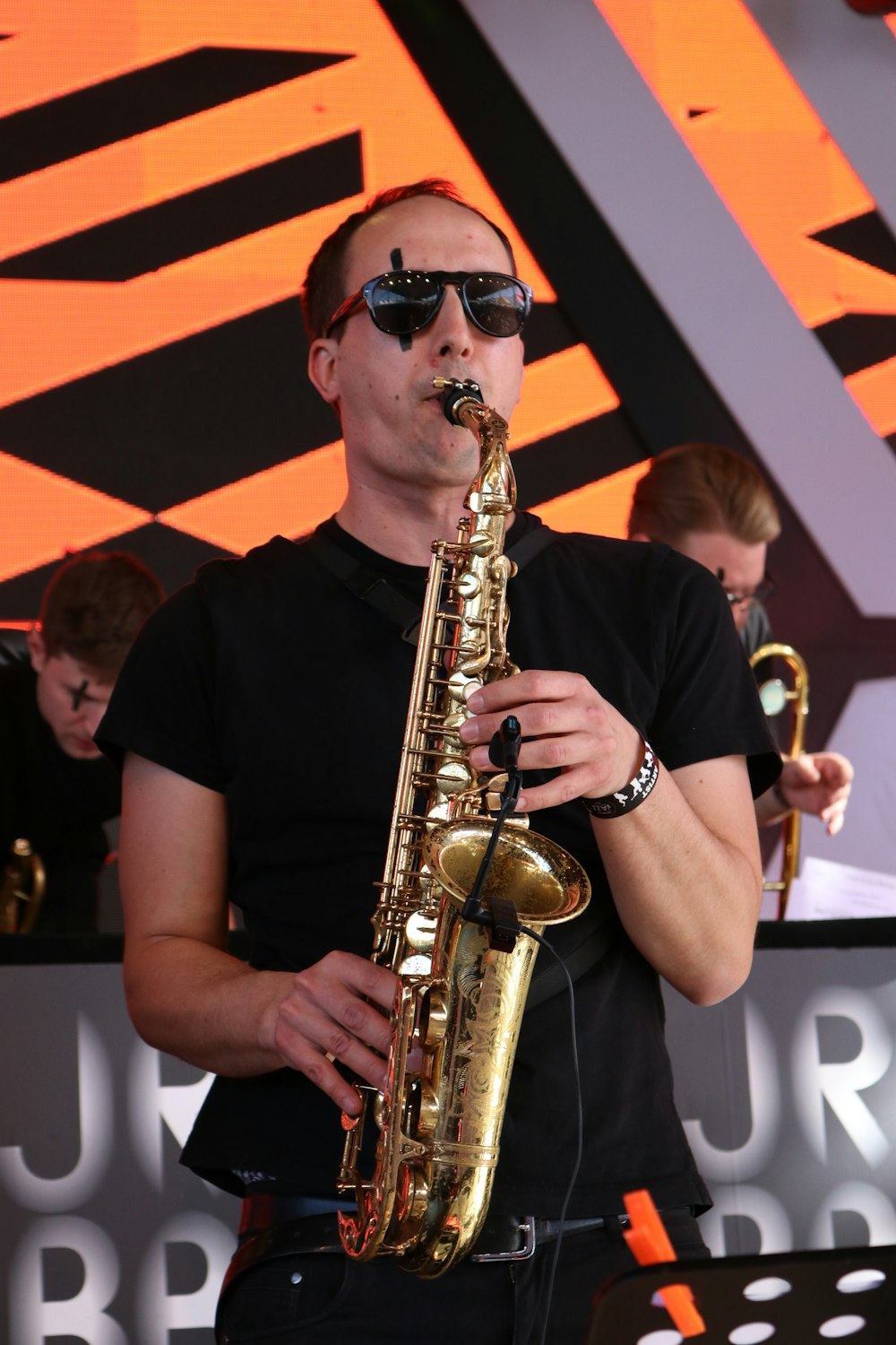 man in black crew-neck t-shirt using saxophone