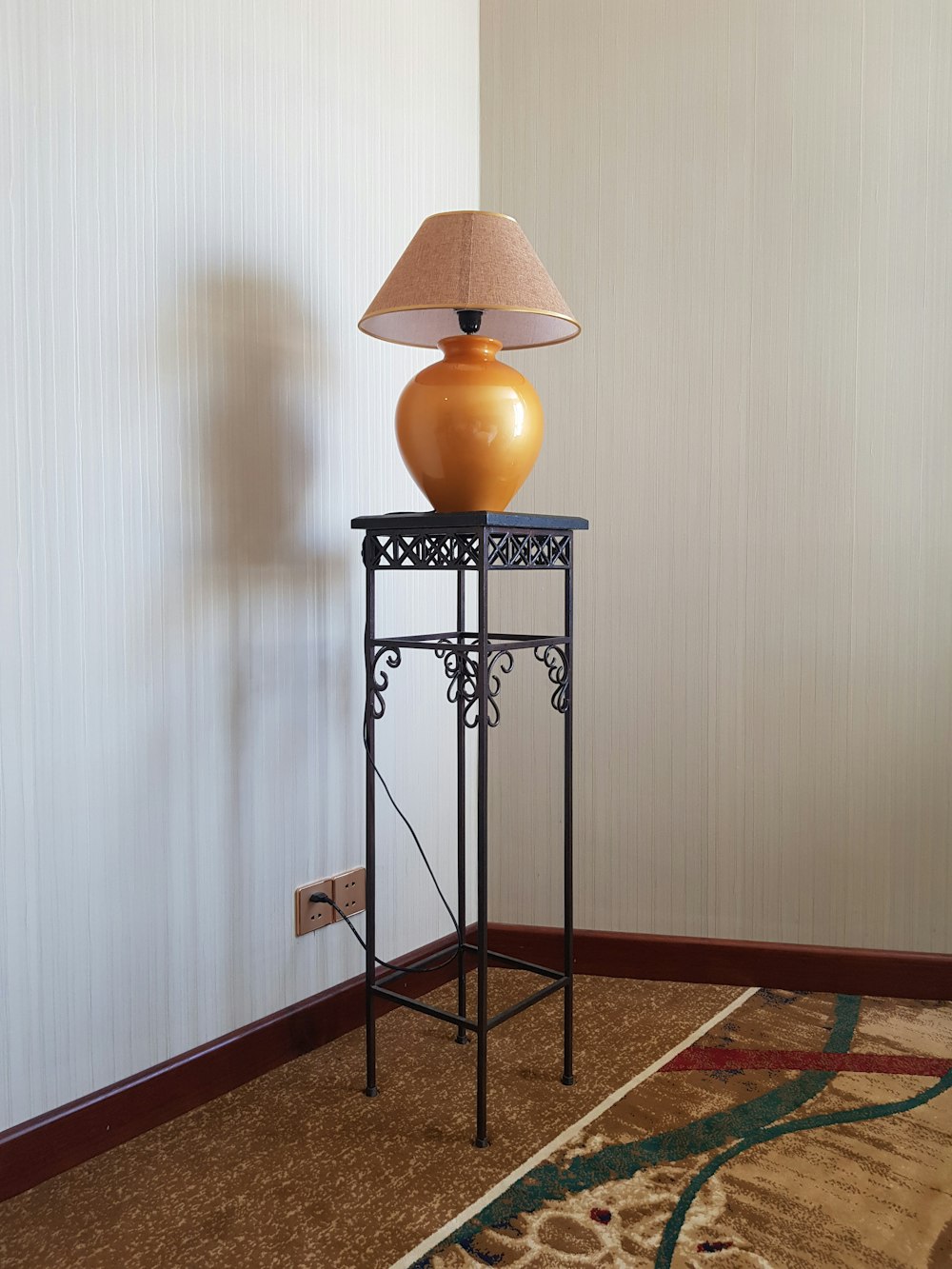 orange table lamp on black wrought iron table