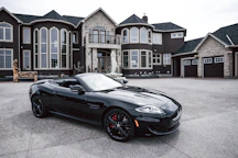black convertible coupe parked near house