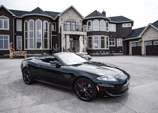 black convertible coupe parked near house